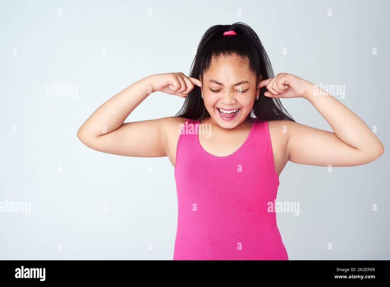 No...no...NOOO. Studioaufnahme eines niedlichen jungen Mädchens mit den Fingern in den Ohren vor einem grauen Hintergrund. Stockfoto