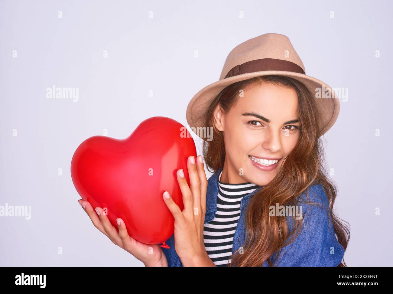 Wirst du mein valentinstag sein. Studioaufnahme einer schönen jungen Frau, die vor einem violetten Hintergrund posiert. Stockfoto