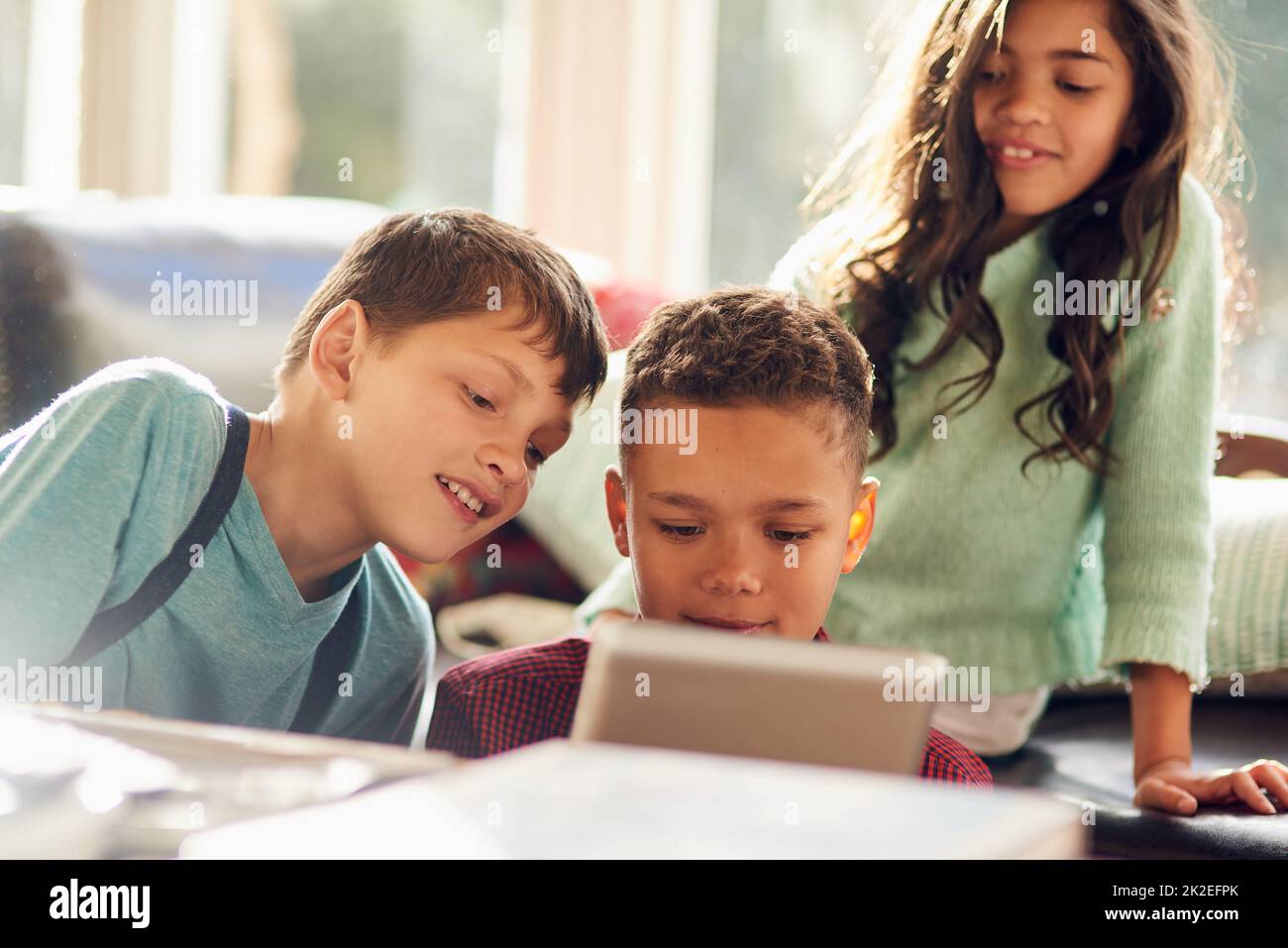 Die Kinder mit Technik beschäftigen. Aufnahme von kleinen Kindern, die zu Hause ein digitales Tablet benutzen. Stockfoto