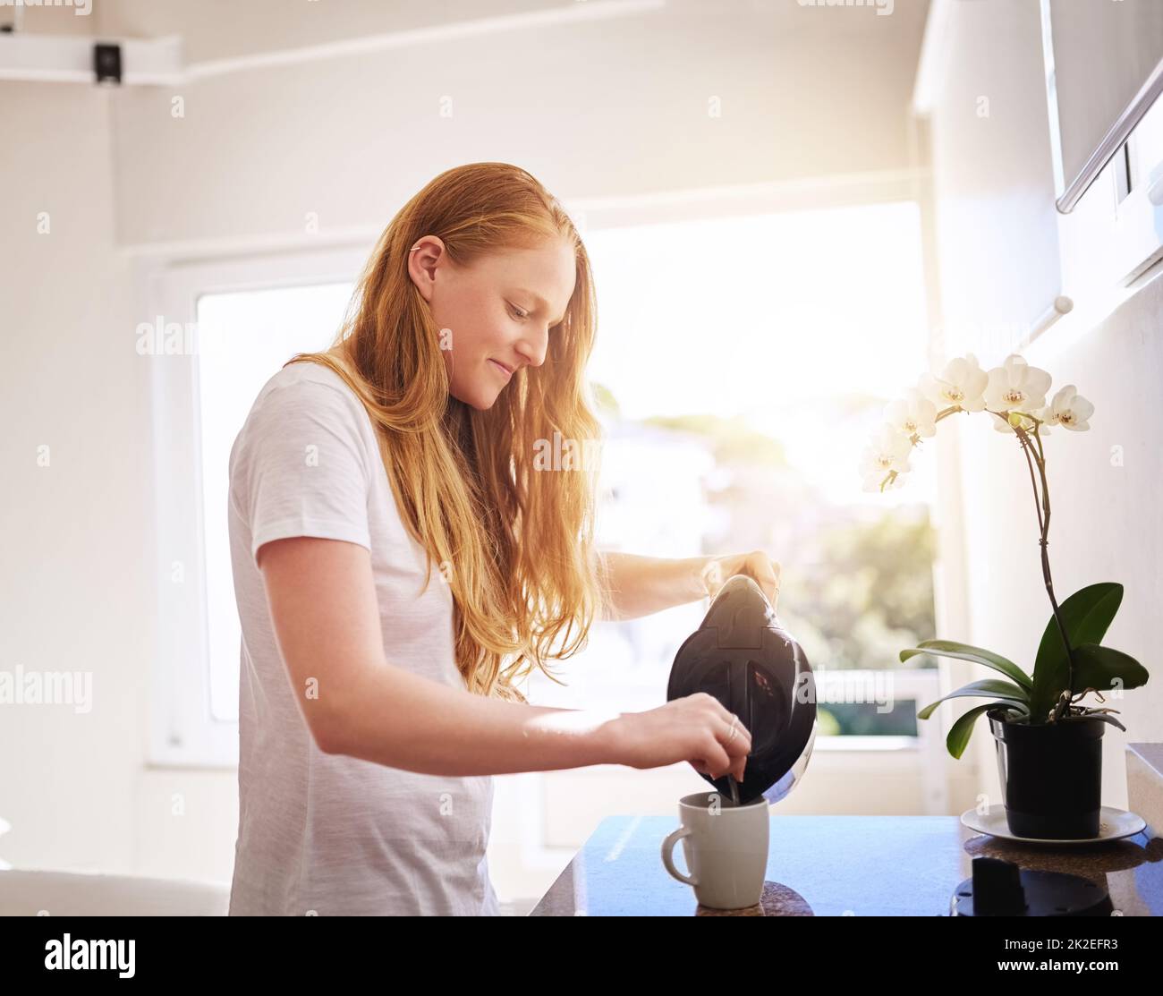 Was morgens ohne Kaffee ist. Aufnahme einer jungen Frau, die zu Hause in der Küche ein heißes Getränk zubereitet. Stockfoto