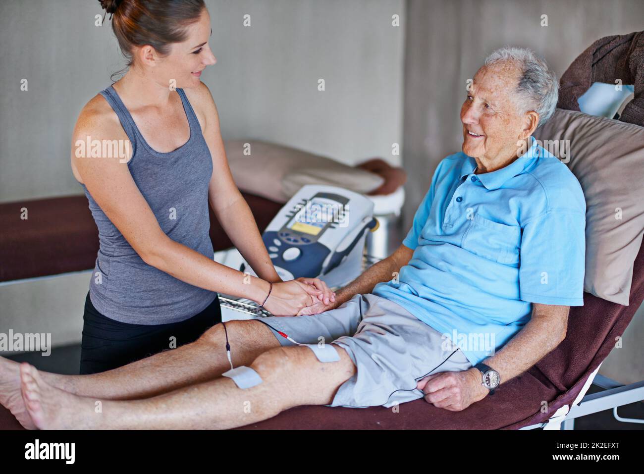 Sie kommen sehr gut voran. Ein älterer Mann, der eine Physiotherapie macht. Stockfoto