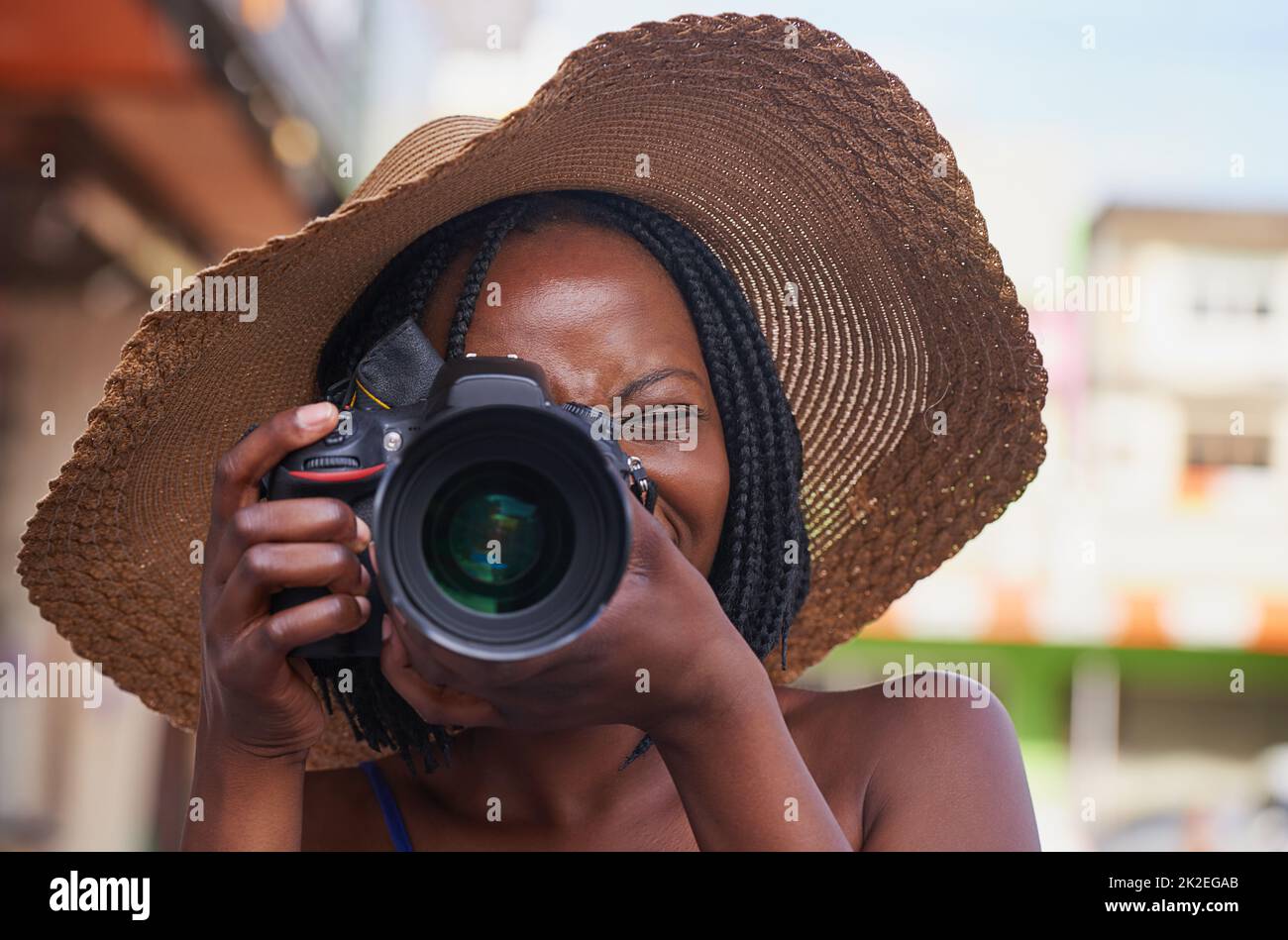 Sie sehen perfekt aus. Porträt einer glücklichen jungen Touristin, die mit ihrer Kamera in einer fremden Stadt fotografiert. Stockfoto