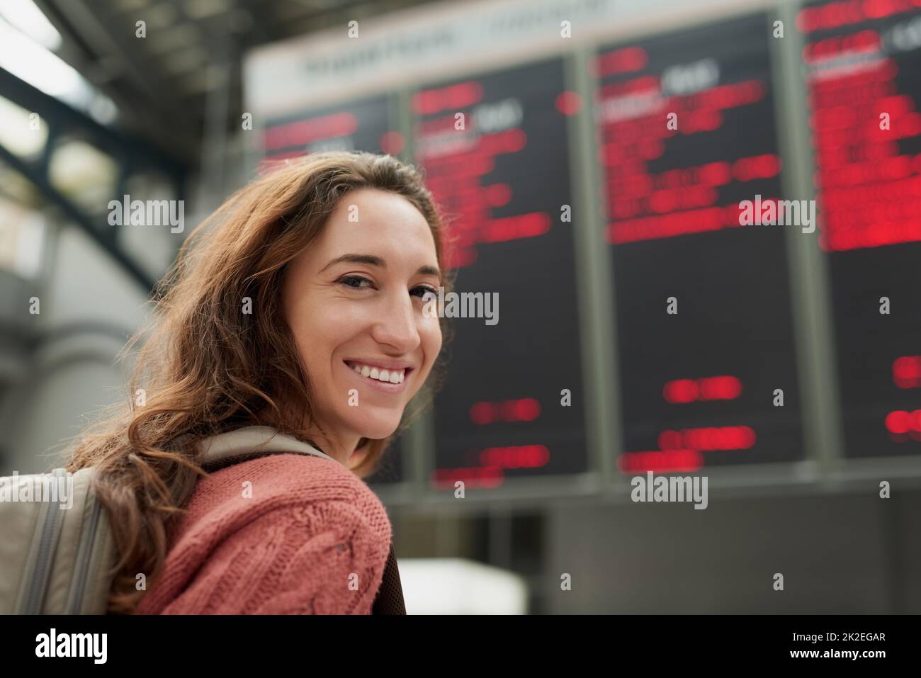 Ich fahre in den Urlaub. Rückfahrporträt einer attraktiven jungen Frau, die auf einem Flughafen steht. Stockfoto