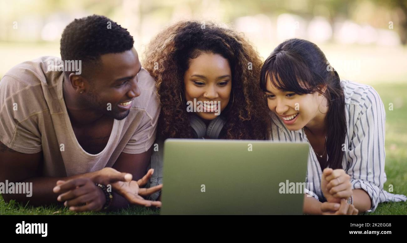 Waren Trending Jungs, was sollten wir als nächstes posten. Aufnahme einer Gruppe von Freunden, die sich hinlegen und gleichzeitig einen Laptop verwenden. Stockfoto