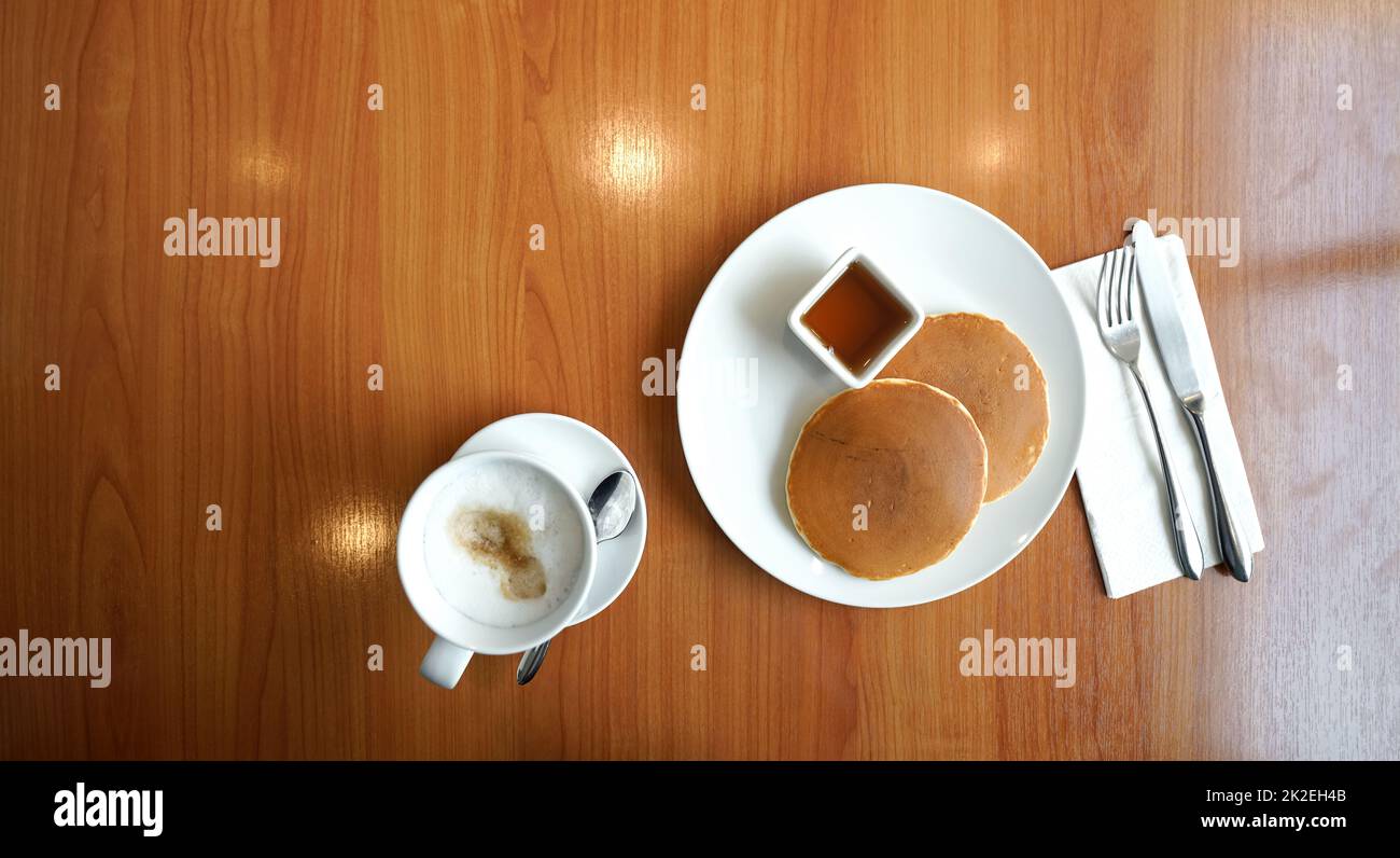 Zwei Pfannkuchen, serviert mit Ahornsirup auf einem Holztisch. Draufsicht. Stockfoto