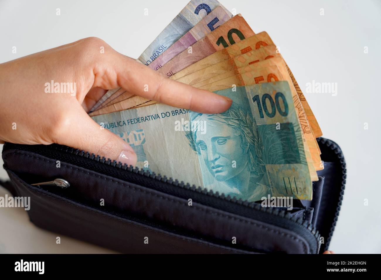 Steigende Preise. Hand nehmen brasilianische Real Banknoten aus der Brieftasche. Rezession. Finanzkrise. Stockfoto