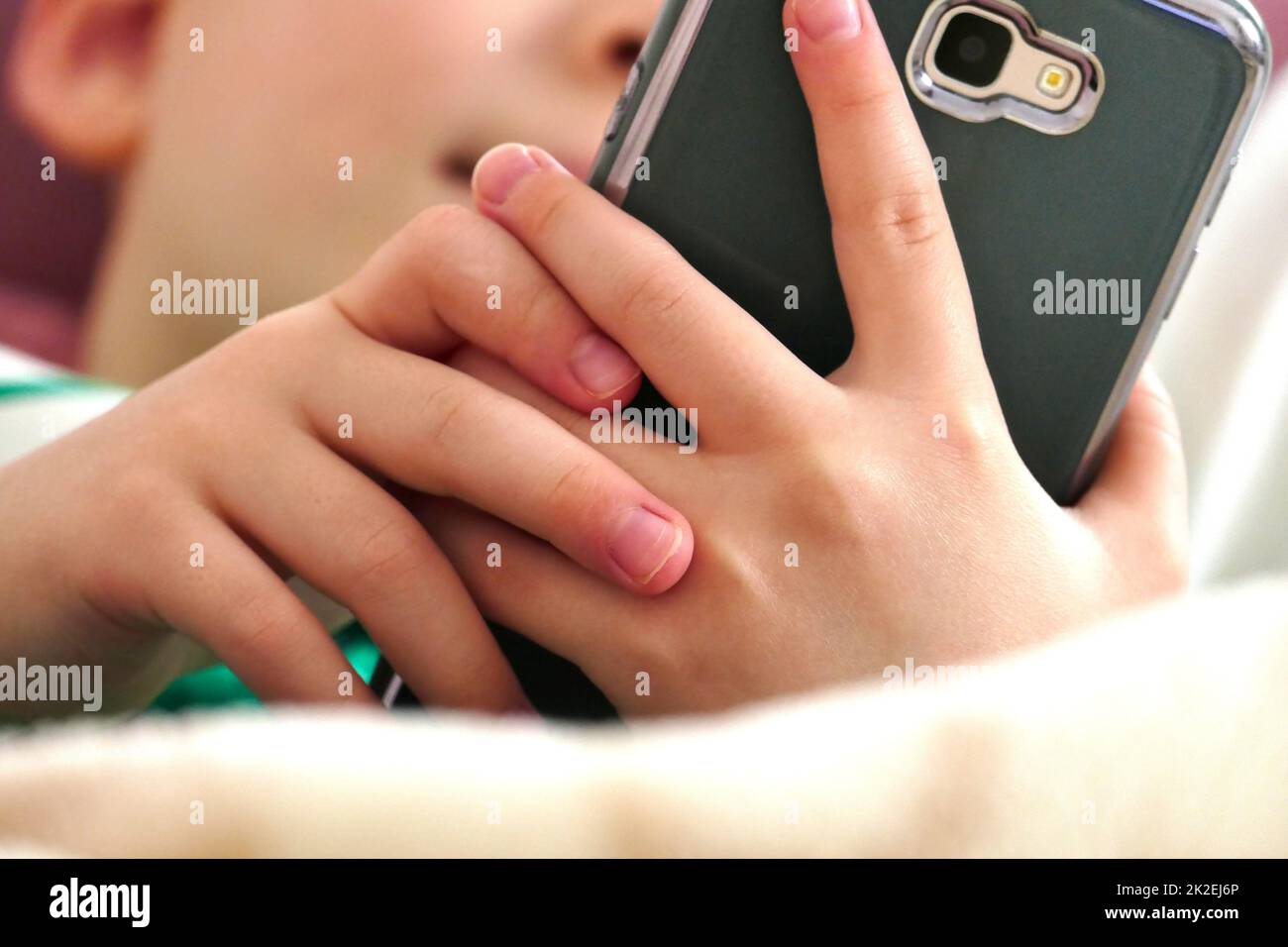 Der Umgang mit einem Smartphone ist für Kinder eine äußerst schädliche Gewohnheit. Stockfoto