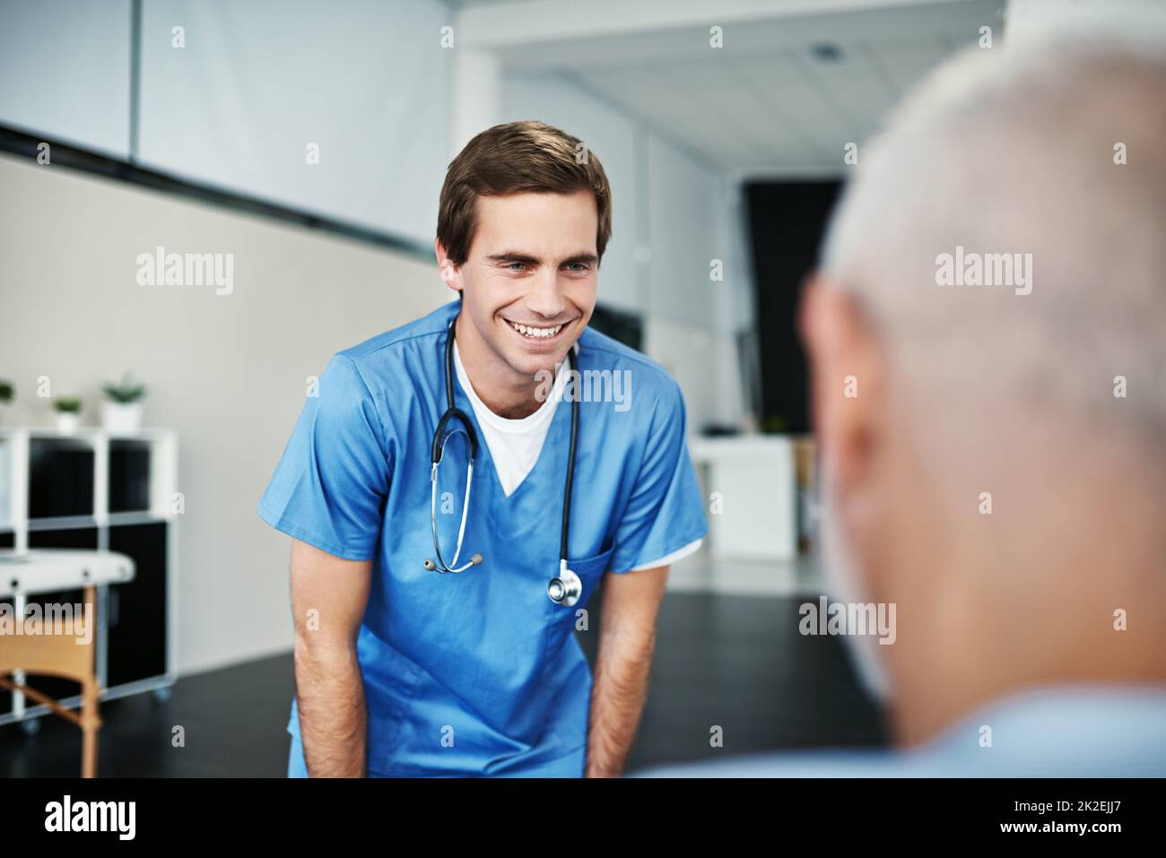 Er dient mit aufrichtiger Barmherzigkeit. Aufnahme eines Krankenpflegers, der sich um einen älteren Patienten kümmert. Stockfoto