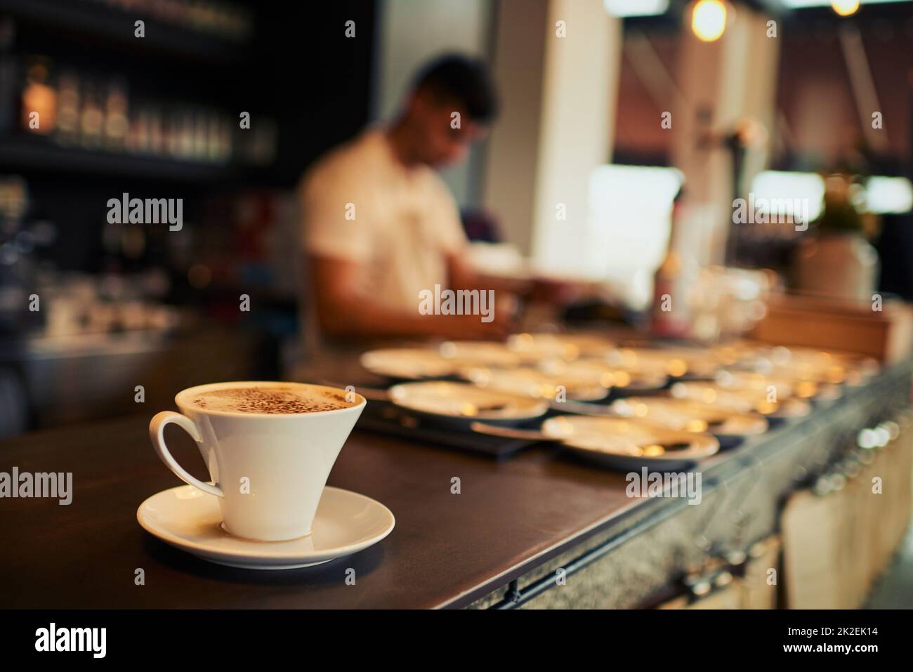 Ausgehen, um einen Kunden glücklich zu machen. Aufnahme einer frisch gebrühten Tasse Kaffee, die tagsüber auf einem Tisch neben dem eigenen Restaurant steht. Stockfoto