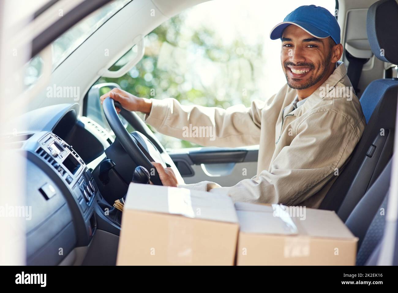 Ich mache meine Runden. Beschnittenes Porträt eines hübschen jungen Mannes, der in seinem Lieferwagen Lieferungen machte. Stockfoto