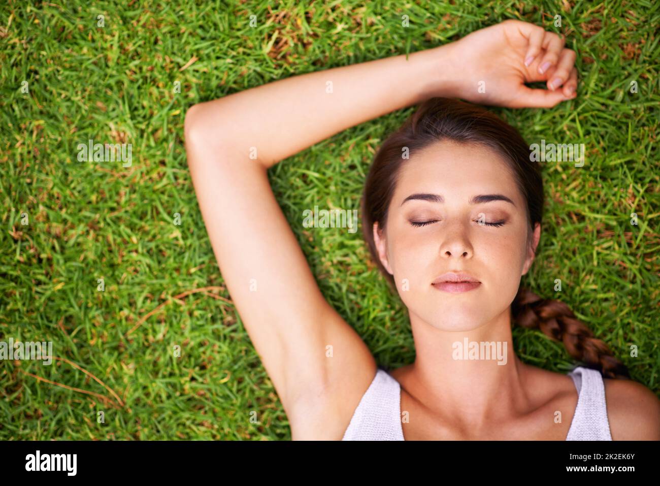 Ich genieße einige Zeit. Eine junge Frau, die draußen auf dem Gras liegt. Stockfoto