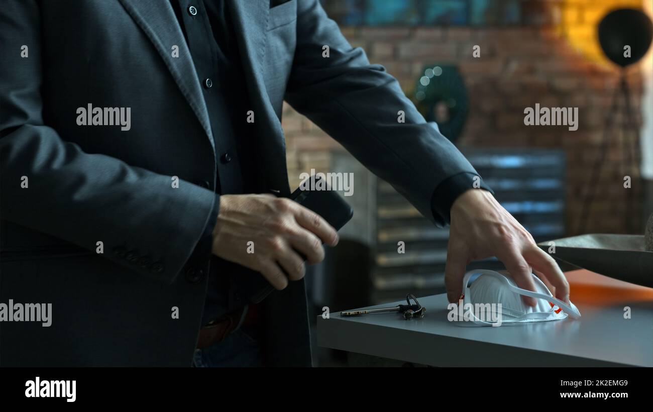 Mann verlässt zu Hause und bekommt Virenschutzmaske Stockfoto