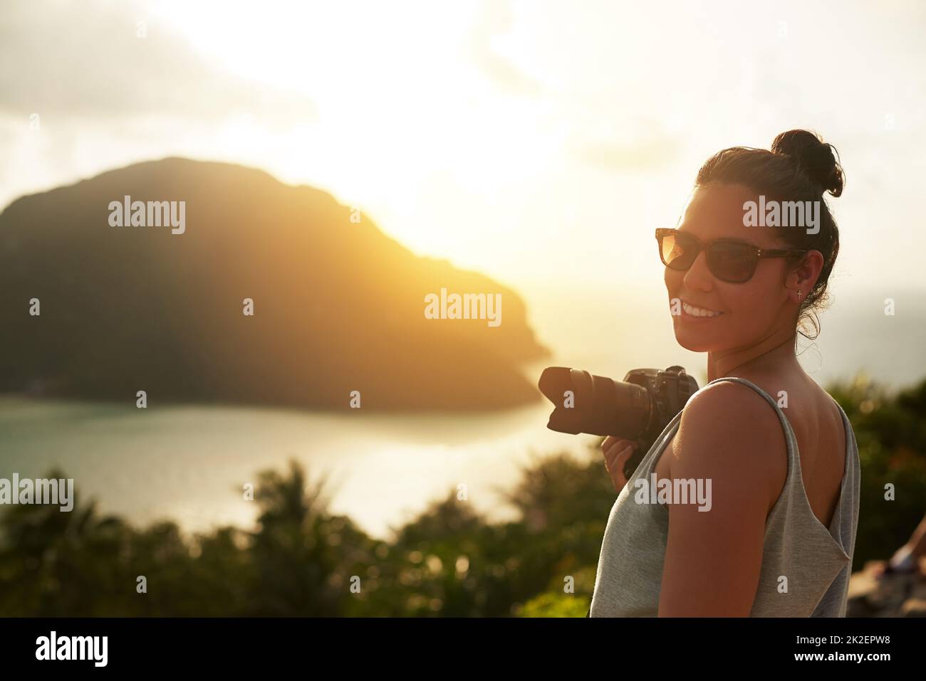 Dies ist eine bildschöne Landschaft. Porträt einer glücklichen jungen Frau, die im Urlaub einen tropischen Ausblick fotografiert. Stockfoto