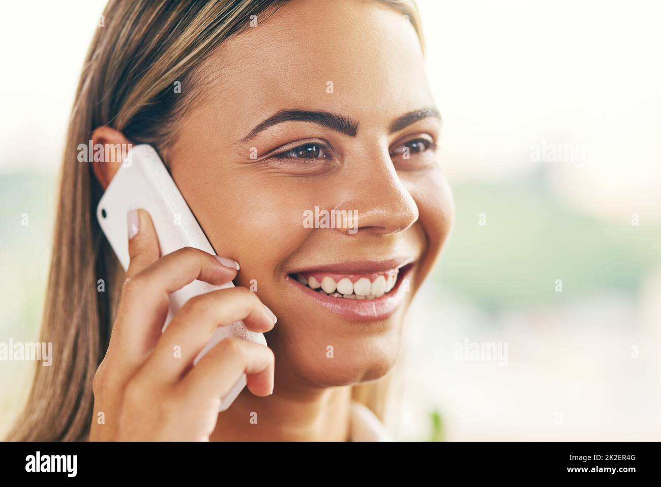 Was für eine angenehme Überraschung, mit Ihnen zu sprechen. Aufnahme einer fröhlichen jungen Frau, die tagsüber in einem Café stand und auf ihrem Handy sprach. Stockfoto