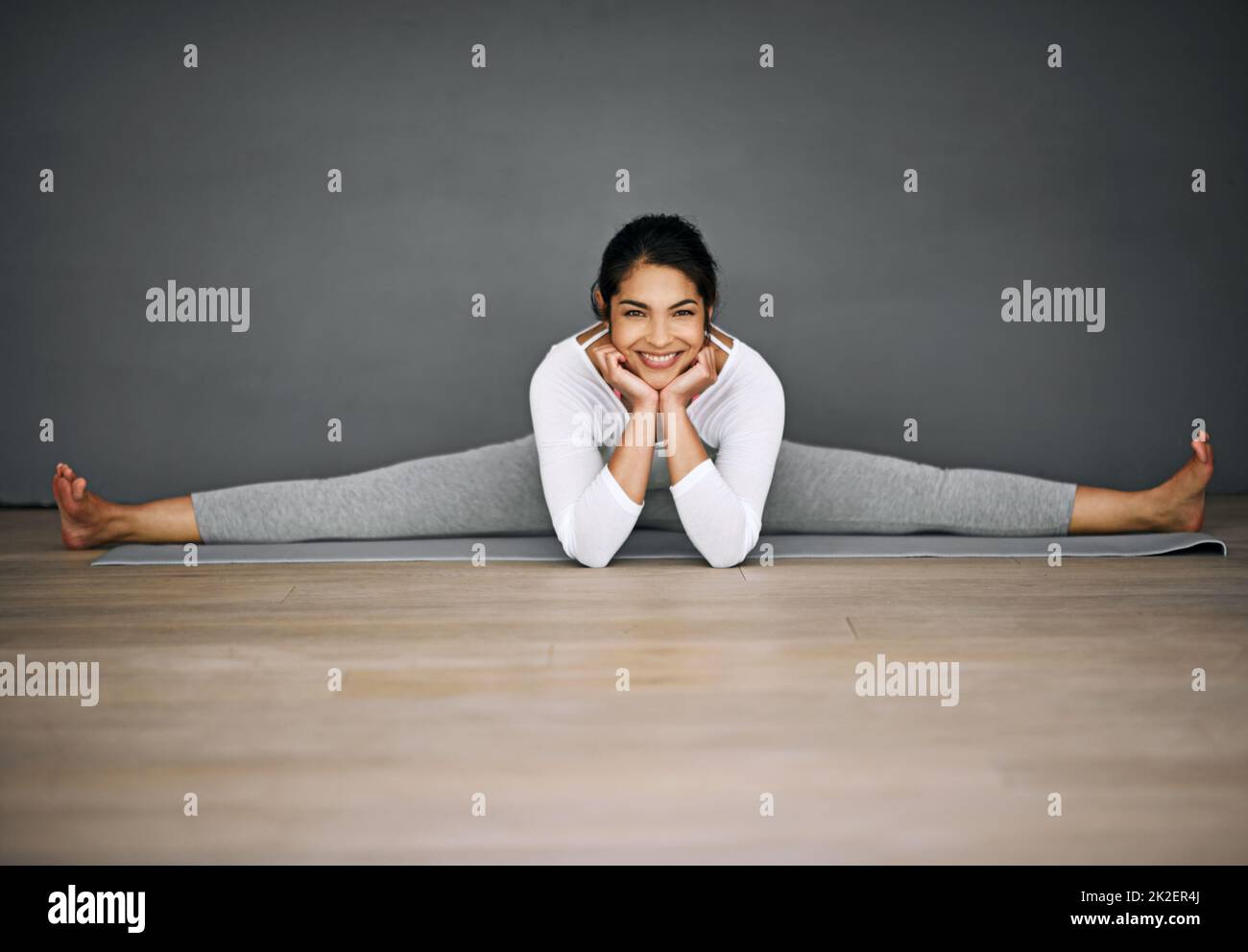 Sie werden erstaunt sein, was Ihr Körper erreichen kann. Porträt einer attraktiven jungen Frau, die die Splits in ihrer Yoga-Routine macht. Stockfoto