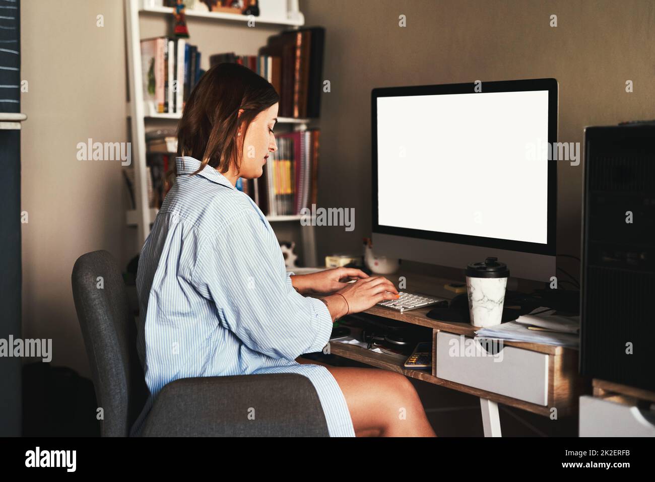 Von zu Hause aus zu arbeiten ist mein Favorit. Eine kurze Aufnahme einer attraktiven jungen Geschäftsfrau, die allein in ihrem Heimbüro sitzt und ihren Computer benutzt. Stockfoto