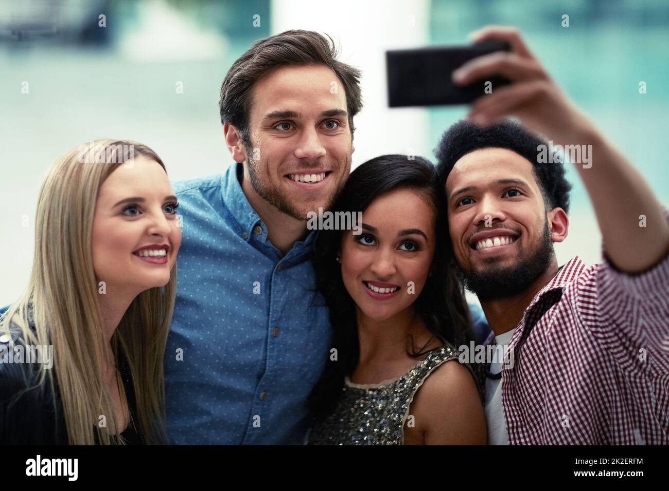 Diese geht direkt auf Social Media. Aufnahme einer glücklichen Gruppe von Freunden, die ein Selfie mit einem Smartphone in einem Nachtclub macht. Stockfoto