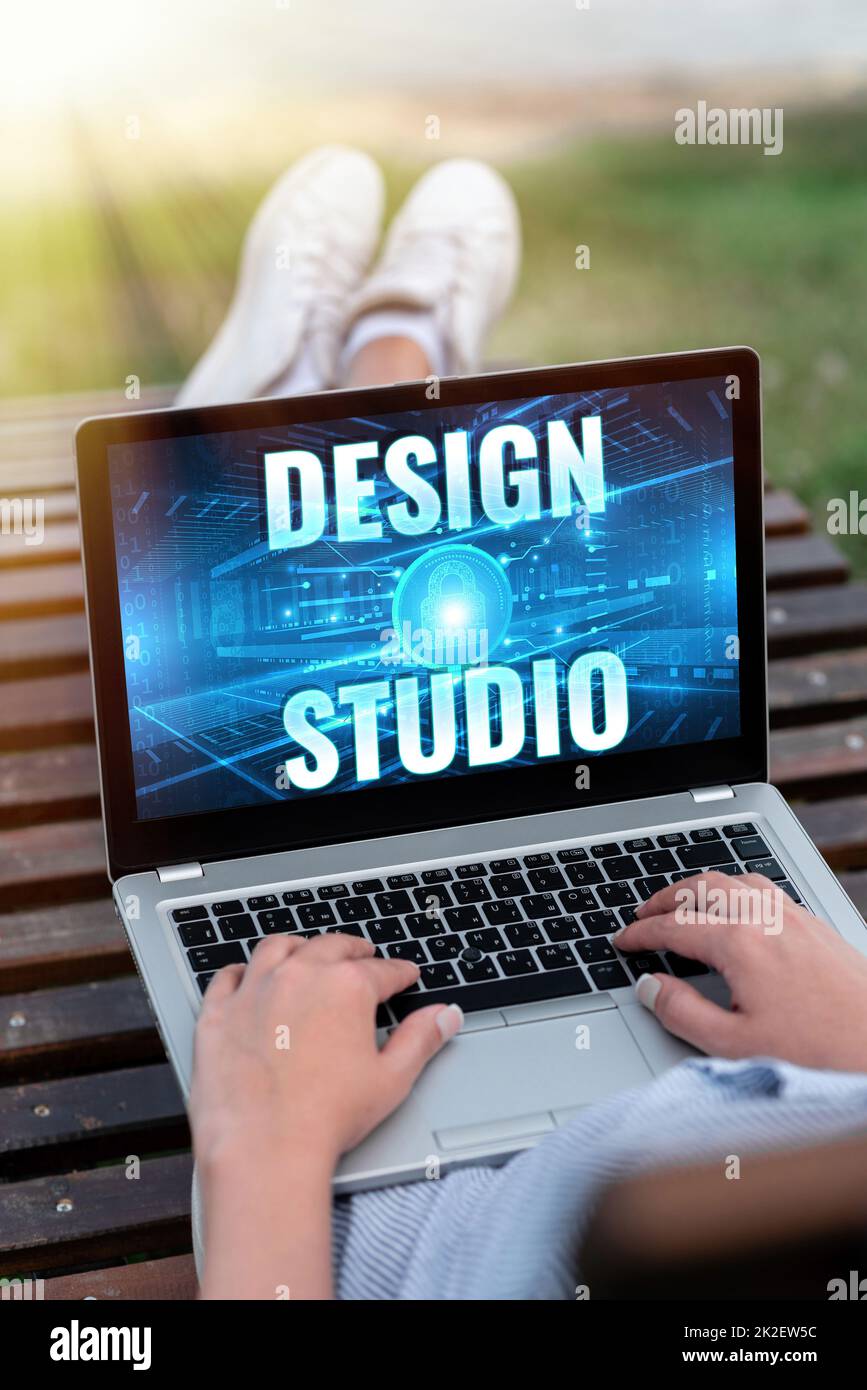 Text mit Inspiration Design Studio. Arbeitsumgebung für Geschäftsideen speziell für Designer und Kunsthandwerker Laptop, der auf dem Schoß einer Frau mit Kreuzbein ruht und Remote Job erledigt. Stockfoto