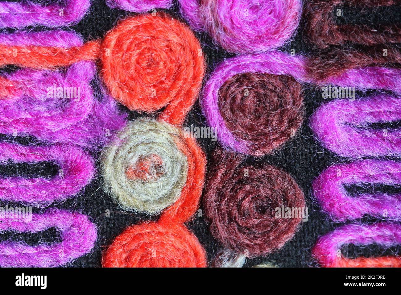 Buntes Strickmaterial Hintergrundstruktur, farbenfrohes Material mit Muster, Matte Nahaufnahme, mehrfarbige Leinwand, Struktur aus Leinen, abstrakt, Fragmentierter farbiger Teppich. Stockfoto