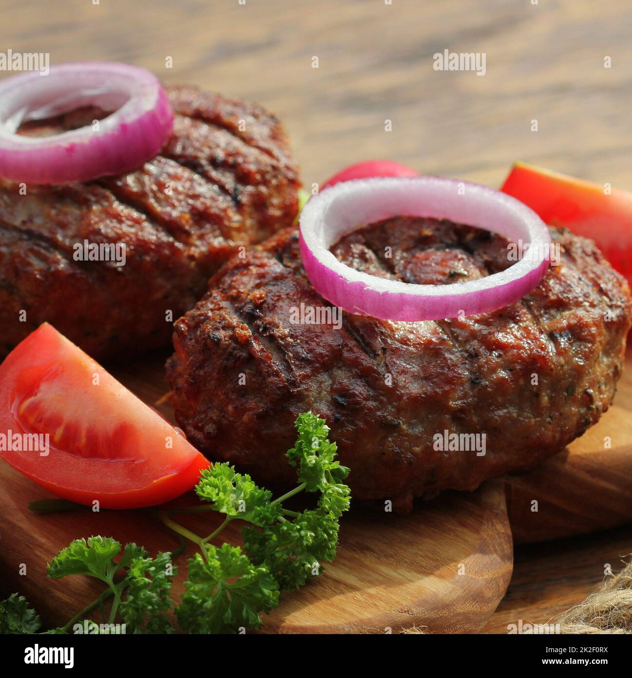 Hausgemachte Rindfleisch-Burger mit Zwiebeln auf Schneidebrett Stockfoto