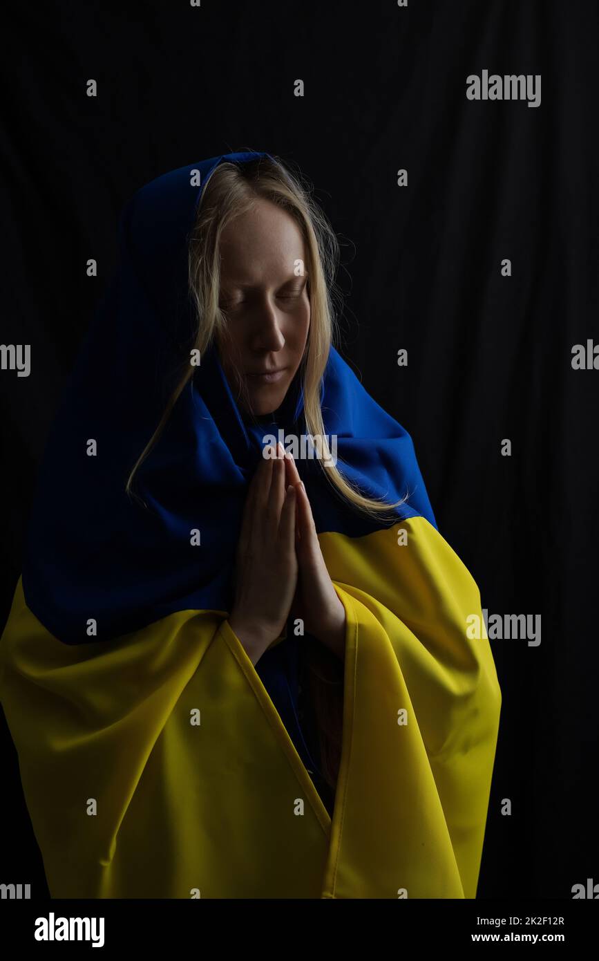 Frau mit Fahne betet, Gott rettet die Ukraine Stockfoto