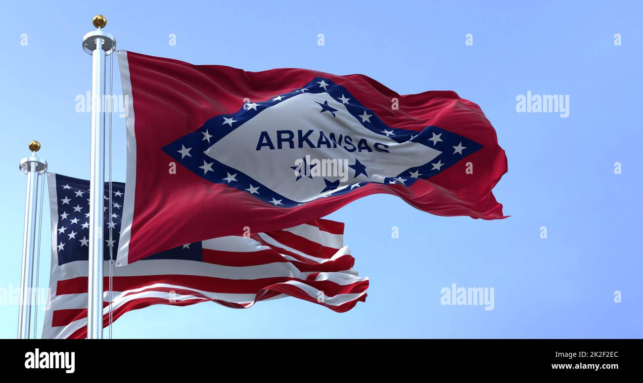 Die Flaggen des Bundesstaates Arkansas und der Vereinigten Staaten winken im Wind. Stockfoto