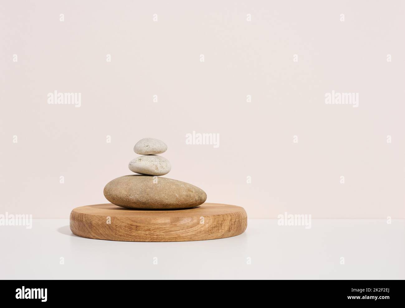 Stapel von runden Steinen auf weißem Hintergrund. Szene für die Demonstration von kosmetischen Produkten, Werbung Stockfoto