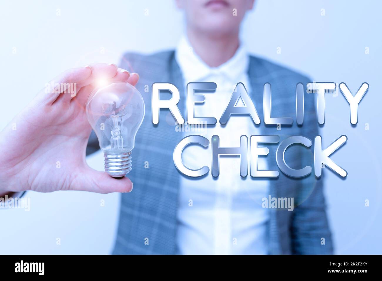 Inspiration für den Zeichen-Reality-Check. Das Wort, das auf einem geschrieben wird, erinnert an den Stand der Dinge in der realen Welt Lady in Business Outfit hält eine Lampe, die neue Technologieideen präsentiert Stockfoto