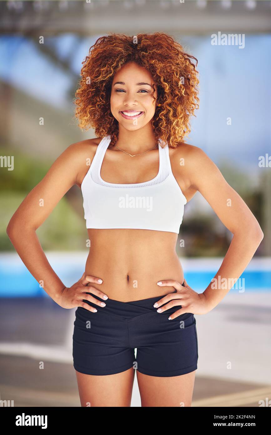 Achten Sie auf Ihren Körper. Aufnahme einer sportlichen jungen Frau, die mit den Händen auf den Hüften posiert. Stockfoto