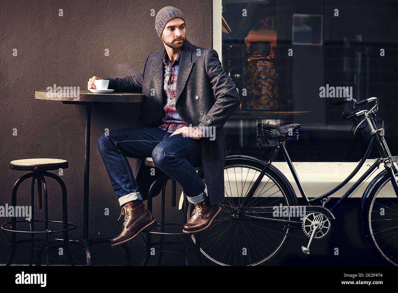 Kaffee ist immer eine gute Idee. Aufnahme eines hübschen jungen Mannes im Winter, der ein Getränk in einem Straßencafé hat. Stockfoto
