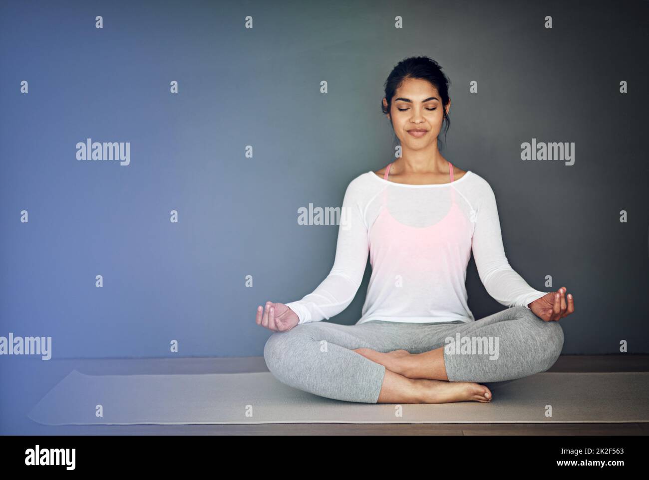 Frieden beginnt bei mir. Aufnahme einer attraktiven jungen Frau, die meditiert. Stockfoto