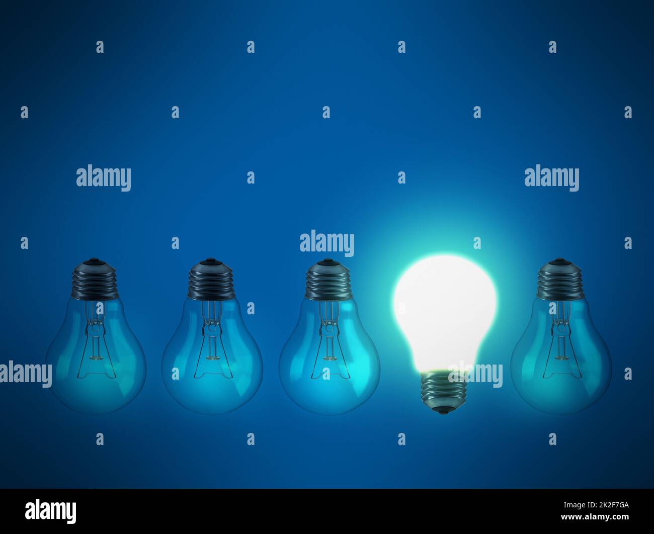 Heben Sie sich von der Masse ab. Studioaufnahme einer Reihe von Glühbirnen vor blauem Hintergrund. Stockfoto