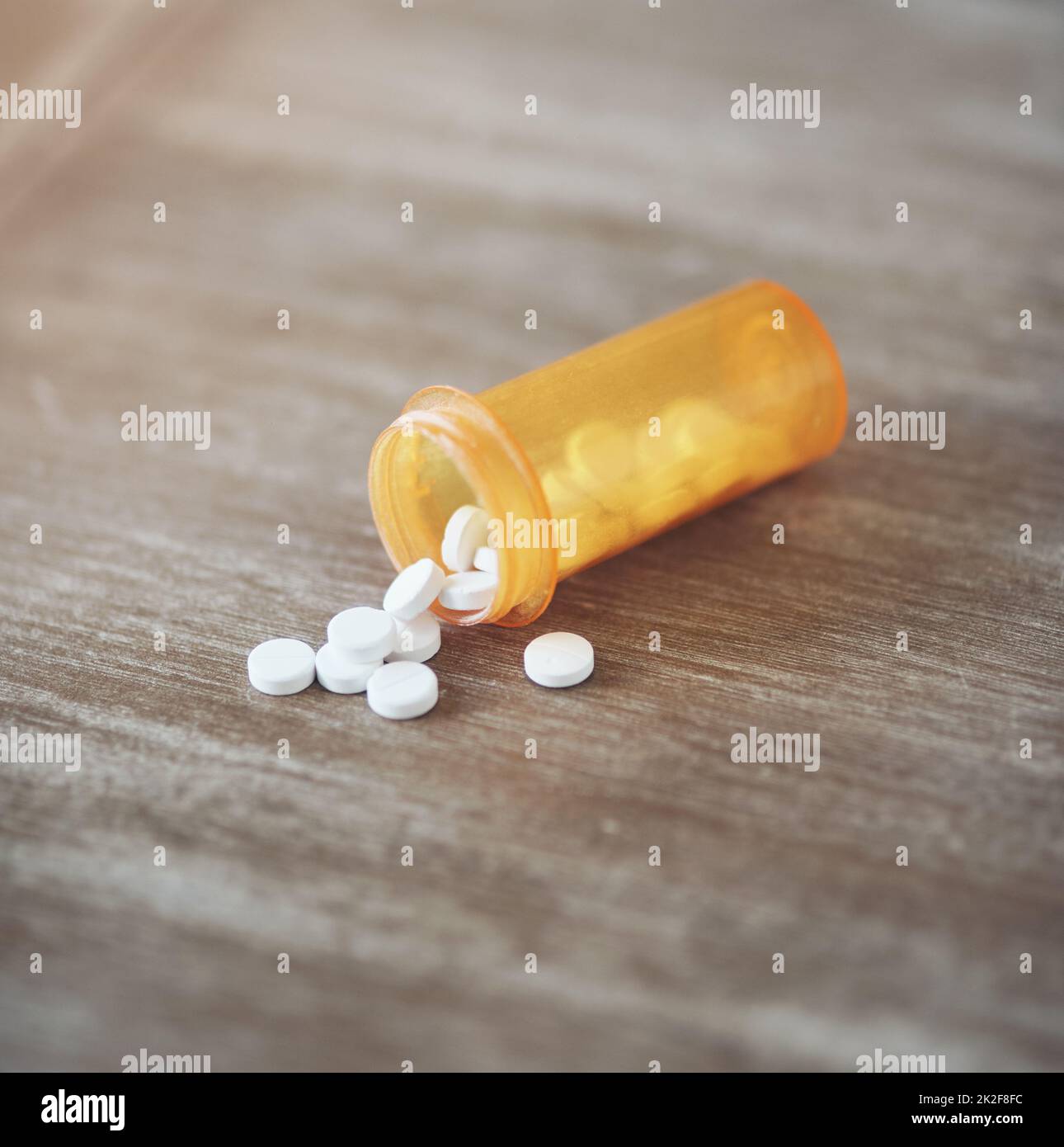 Wie viele Schmerzmittel sind zu viele. Aufnahme einer Flasche Pillen, die tagsüber auf einem Tisch in einem Wohnzimmer offen lag. Stockfoto