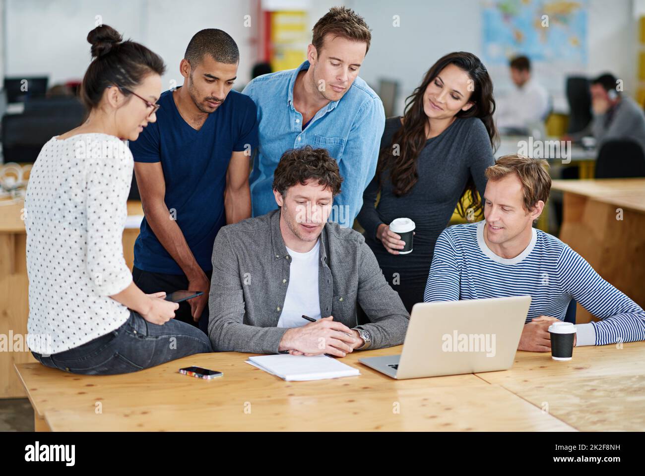 Die Verschmelzung kreativer Köpfe. Aufnahme einer Gruppe von Kollegen, die in einer zwanglosen Arbeitsumgebung zusammen einen Laptop verwenden. Stockfoto