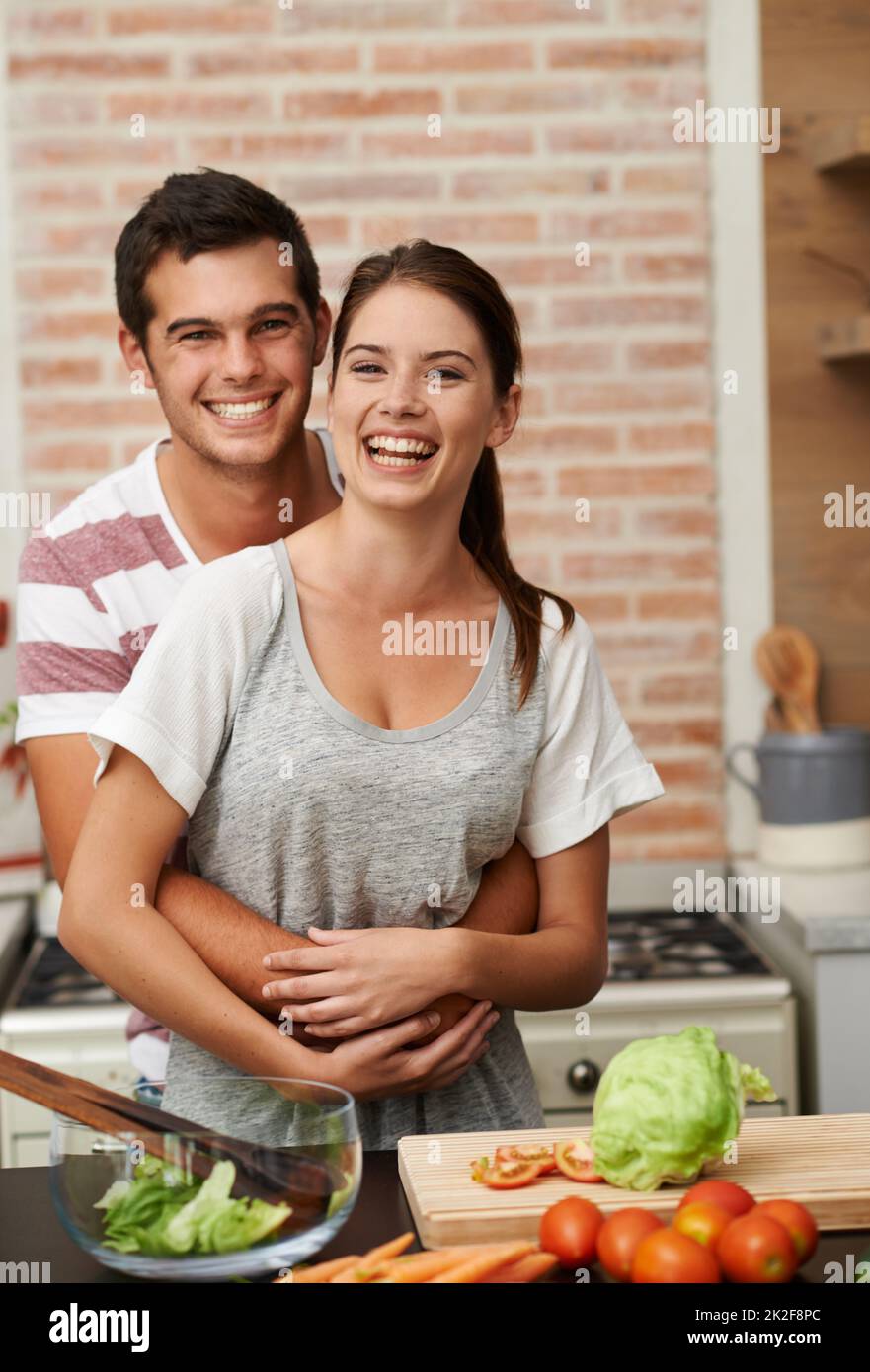 Ihre geheime Zutat ist Liebe. Porträt eines attraktiven jungen Paares, das sich in der Küche verklebt. Stockfoto