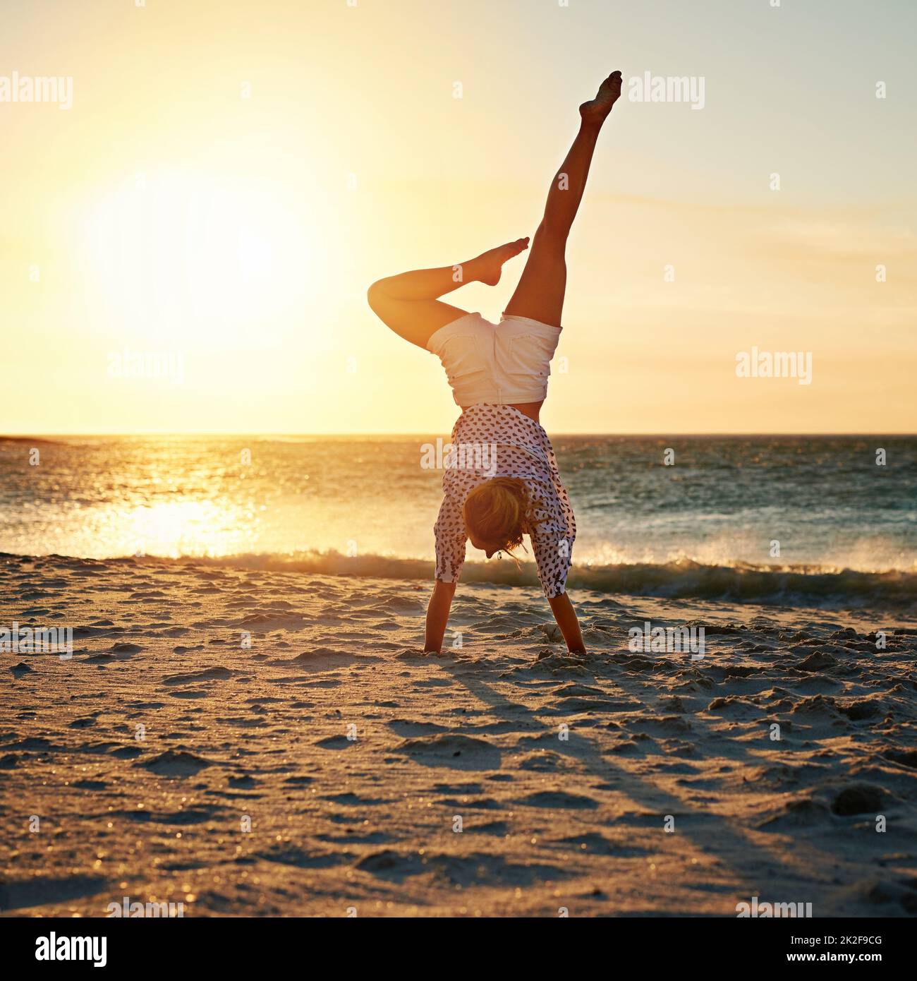 Der beste Ort, um ihre Yoga-Fähigkeiten zu üben. Aufnahme einer unerkennbaren Frau am Strand. Stockfoto