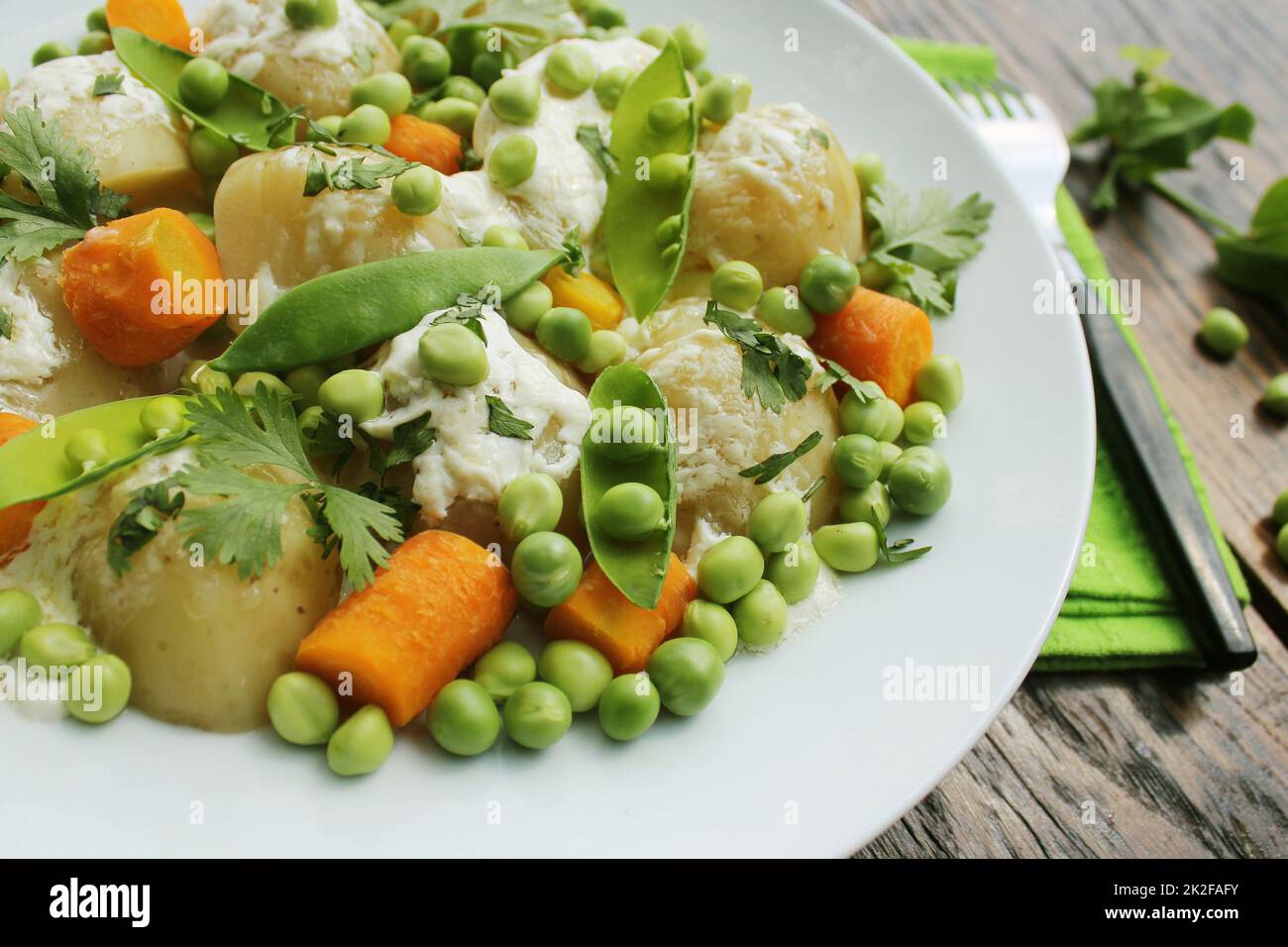 Kartoffelsalat mit Erbsen, Karotten und Koriander Stockfoto