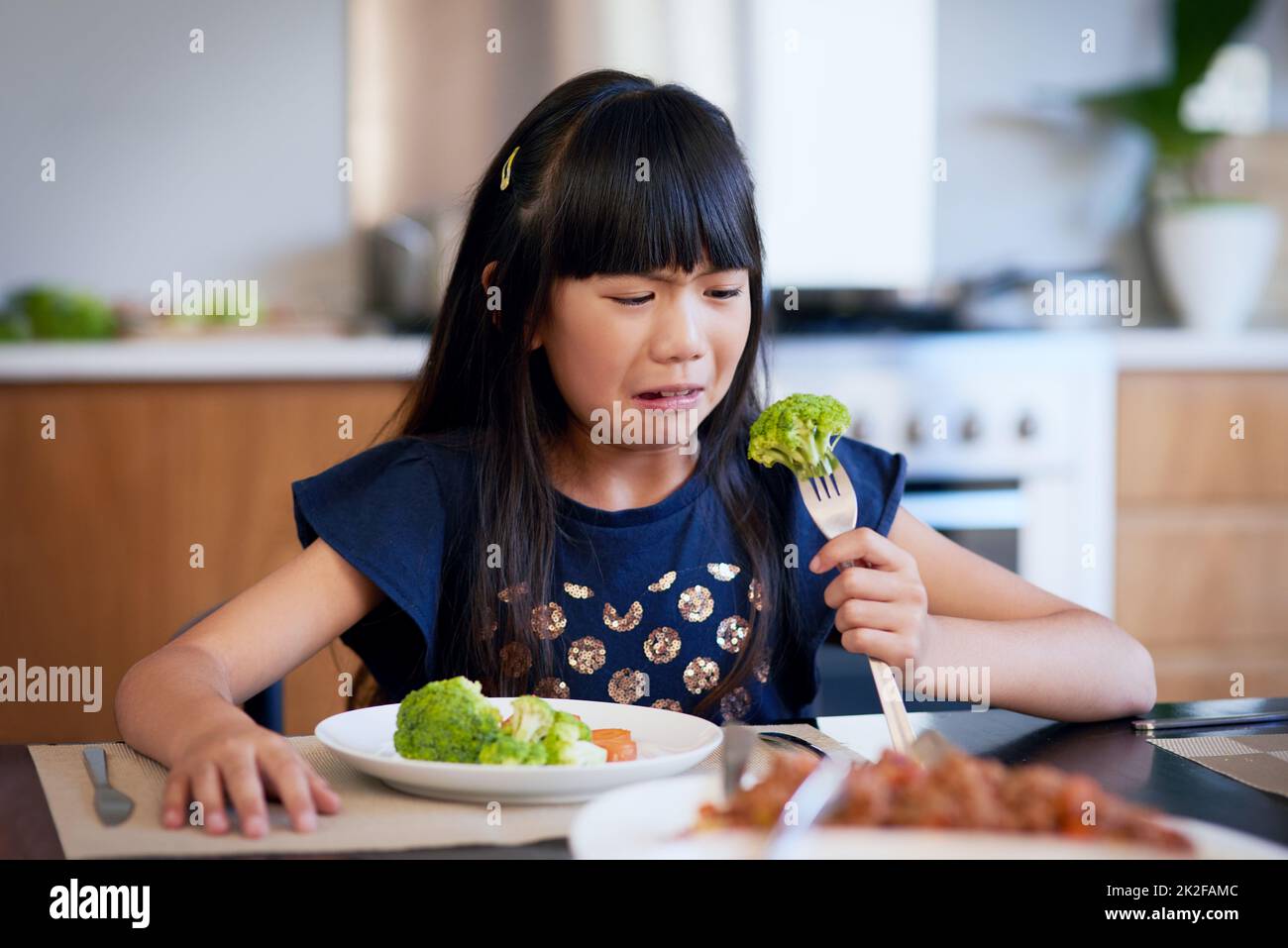 Urgh, ich hasse den Geschmack davon. Aufnahme eines kleinen Mädchens, das sich weigert, ihren Brokkoli zu essen. Stockfoto
