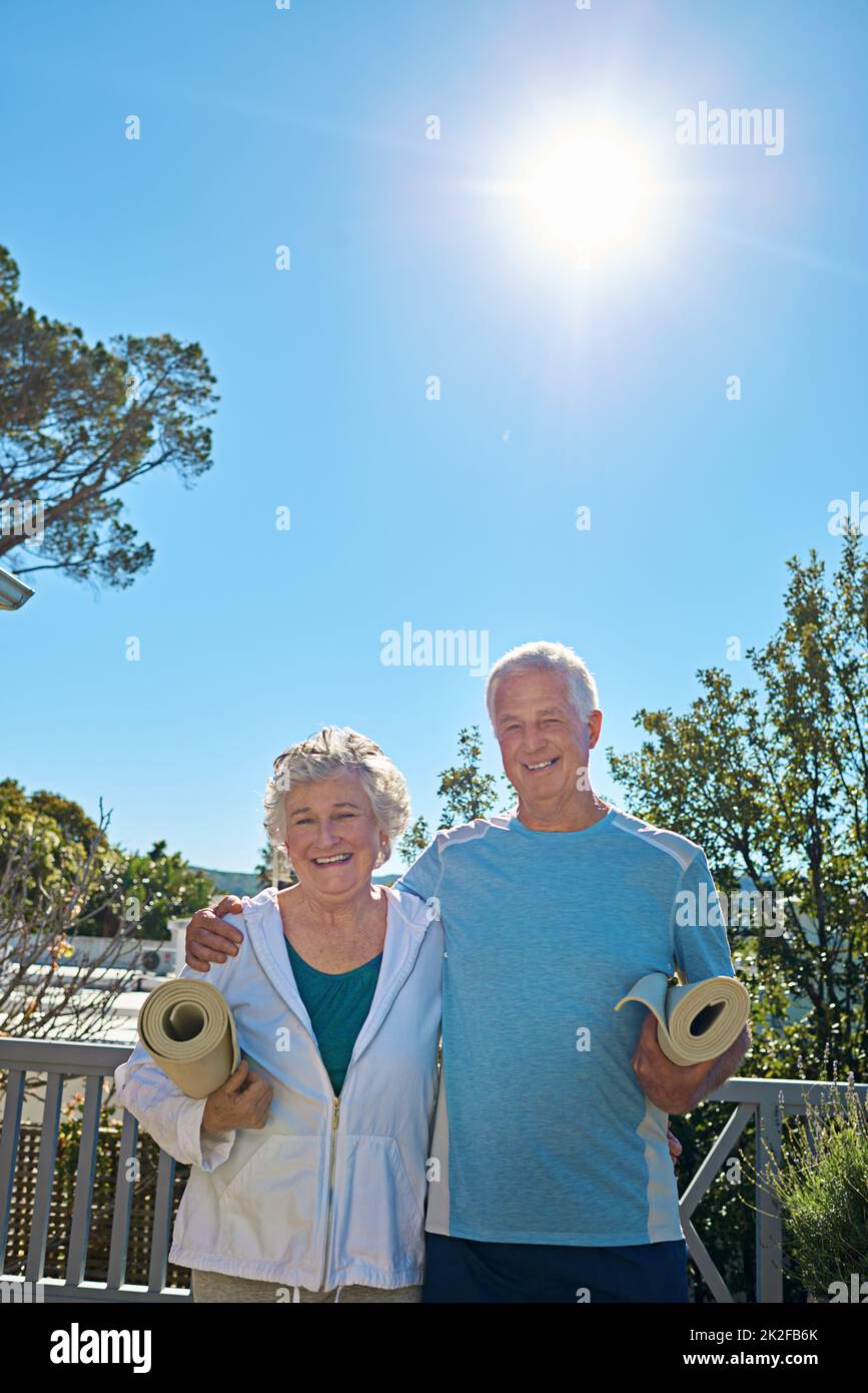 Aktiv und glücklich im Ruhestand. Porträt eines älteren Paares, das draußen steht und gemeinsam Yoga machen will. Stockfoto