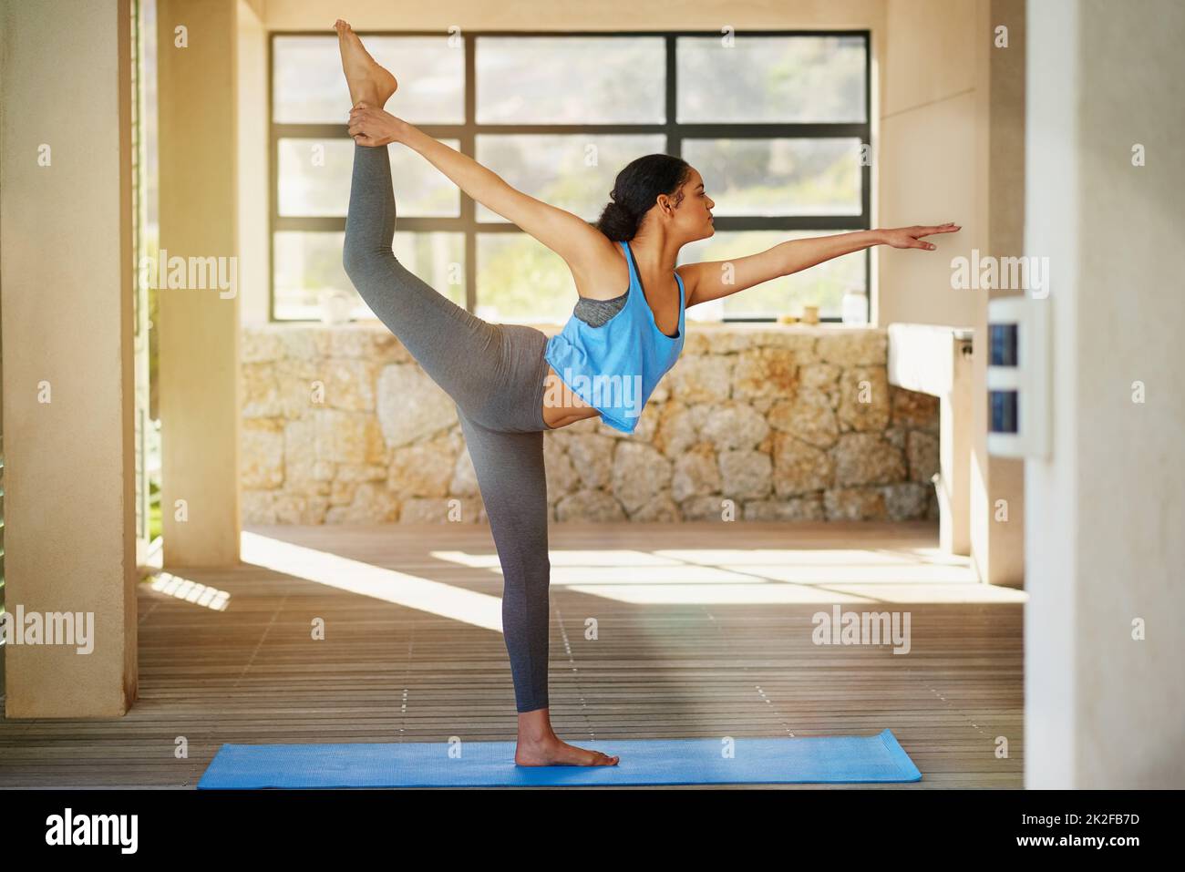 Der Aufstieg zu einem gesunden Lebensstil. Aufnahme einer jungen Frau, die zu Hause Yoga praktiziert. Stockfoto