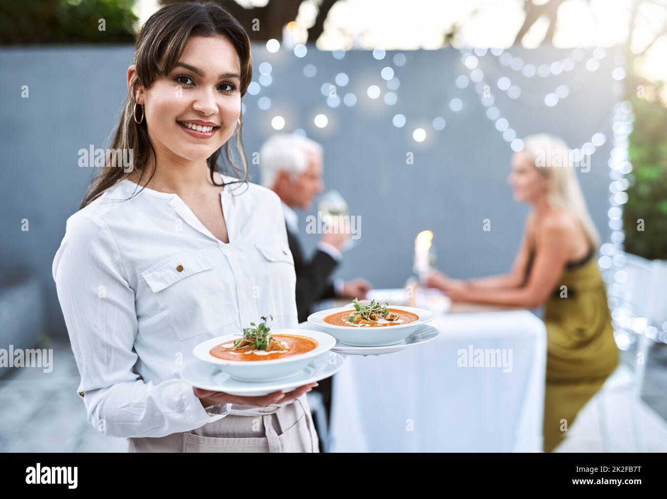 Sie werden diese Vorspeisen lieben. Aufnahme einer jungen Kellnerin, die ein reifes Paar zu einem romantischen Date serviert. Stockfoto