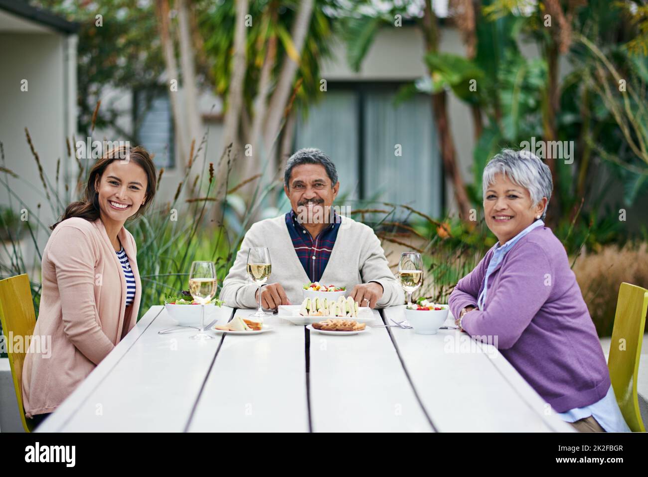 Zusammen ist ihr Lieblingsort. Beschnittenes Porträt einer Familie, die gemeinsam im Freien ein Mittagessen genießt. Stockfoto