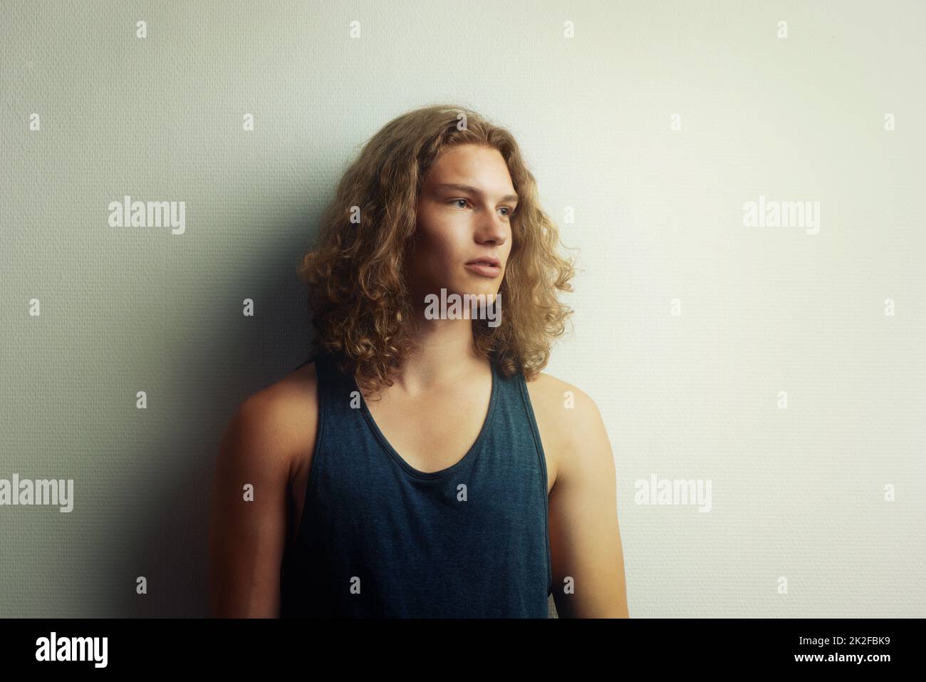 Tagträumer. Ein hübscher, trendiger junger Mann, der eine Weste trägt. Stockfoto