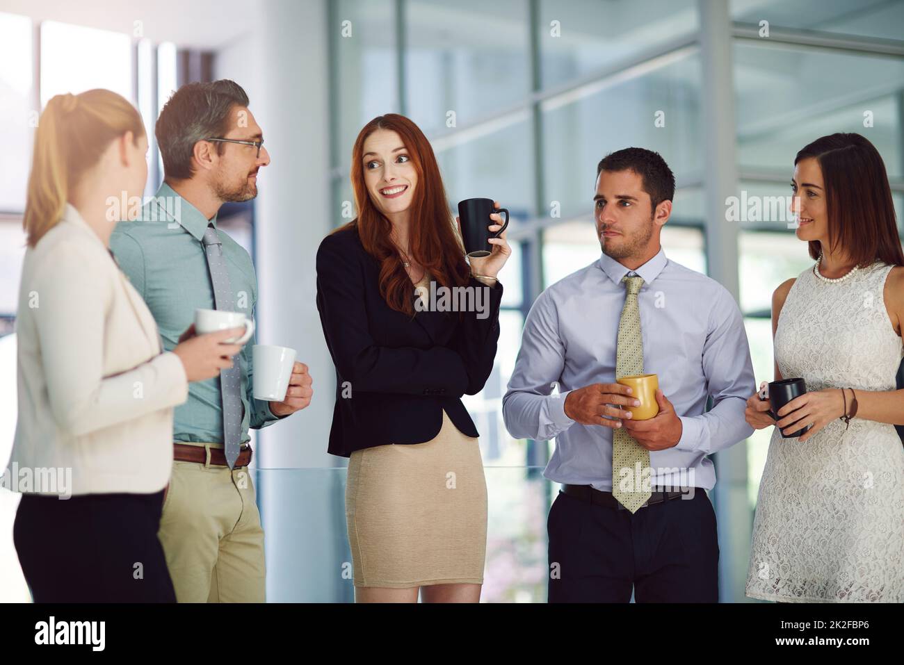 Kaffee erleichtert immer wichtige Diskussionen. Aufnahme von Kollegen, die in einem modernen Büro eine Diskussion führen und Kaffee trinken. Stockfoto