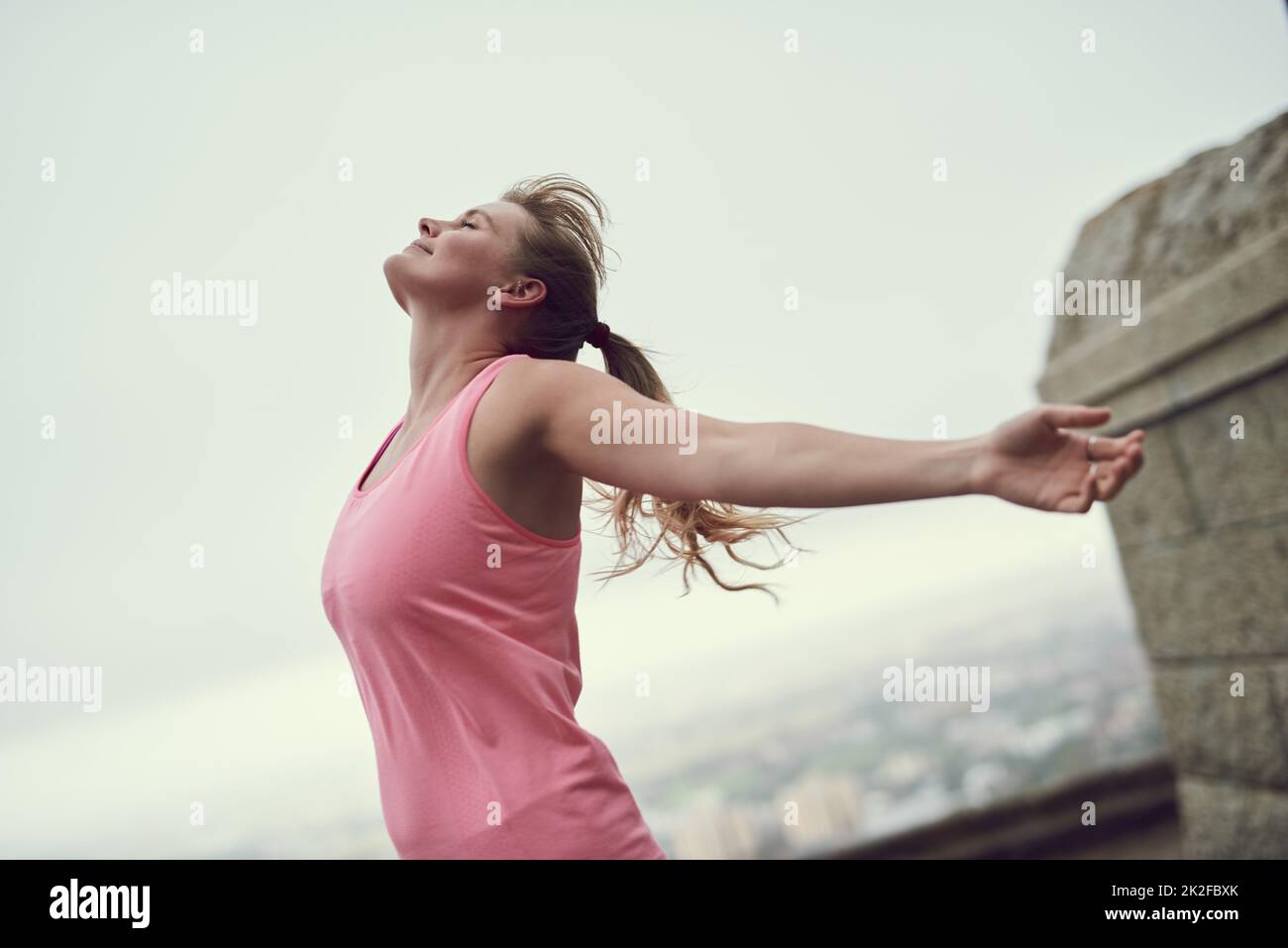 Nichts fühlt sich besser an als Fitness. Aufnahme einer glücklichen jungen Frau, die sich während eines Laufs in der Stadt frei fühlt. Stockfoto