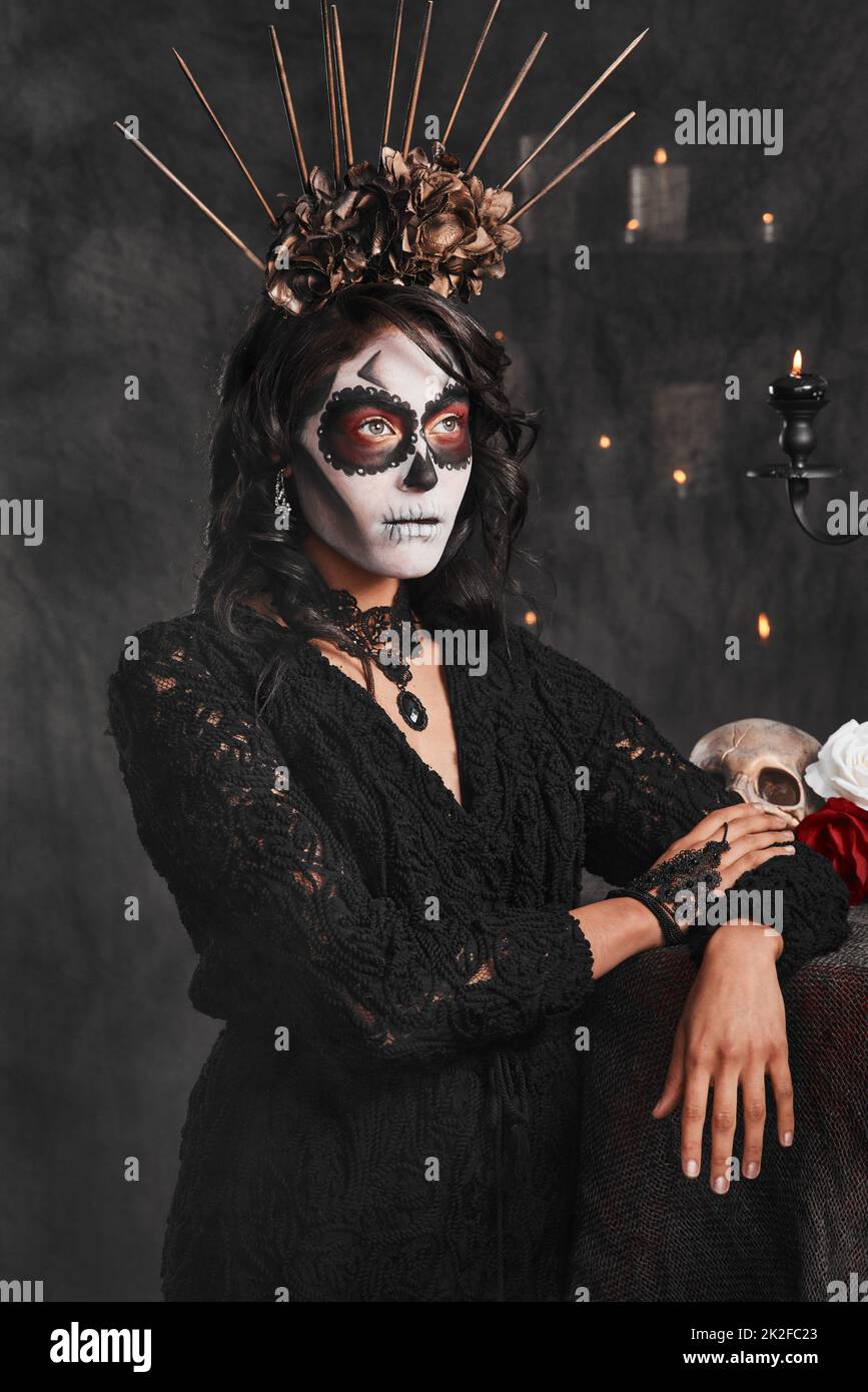 Es ist mehr als eine Tradition. Kurzer Schuss einer attraktiven jungen Frau in ihrem mexikanischen Halloween-Kostüm. Stockfoto