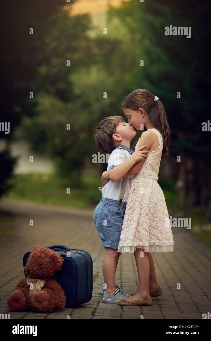 Familie bedeutet Liebe für immer. Aufnahme eines niedlichen kleinen Mädchens, das ihren kleinen Bruder küsst, während sie draußen spielen. Stockfoto