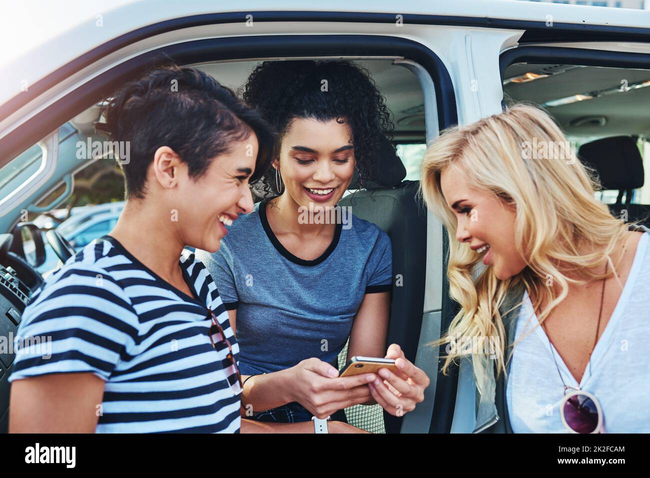 Sollte ich unser Reiseziel online teilen? Aufnahme von Freunden, die auf einem Handy unterwegs etwas angeschaut haben. Stockfoto