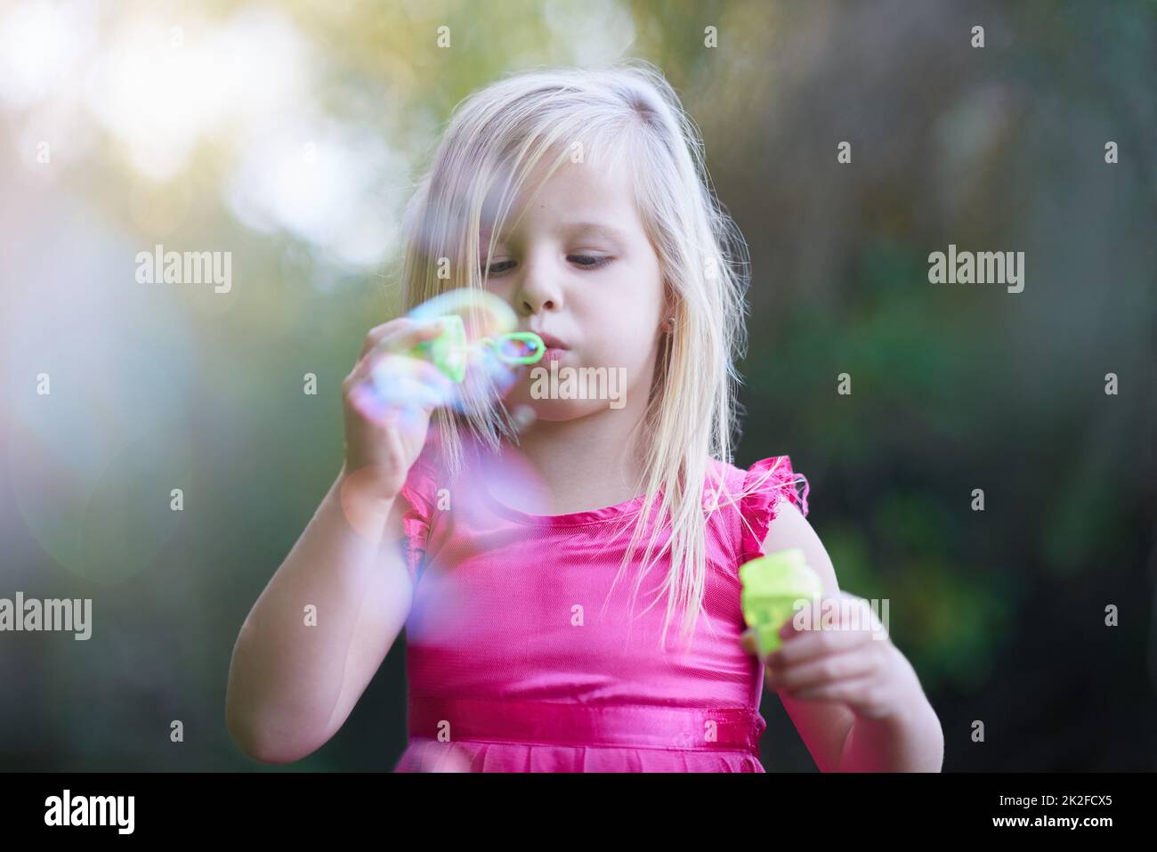 Den Sommer mit ein paar lustigen Zeiten füllen. Kurzer Schuss eines niedlichen kleinen Mädchens, das draußen spielt. Stockfoto