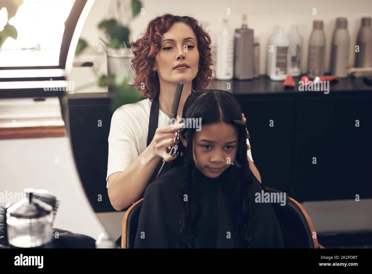 Ich spreche Haare. Englisch ist meine zweite Sprache. Aufnahme eines kleinen Mädchens, das sich im Salon die Haare gemacht hat. Stockfoto